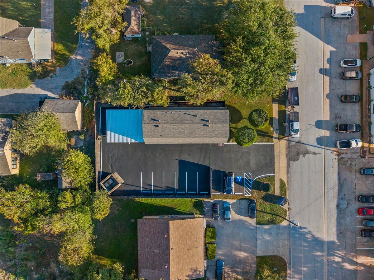 Aerial view of 207 N Tarrant Street, its parking lot and fenced rear lot
