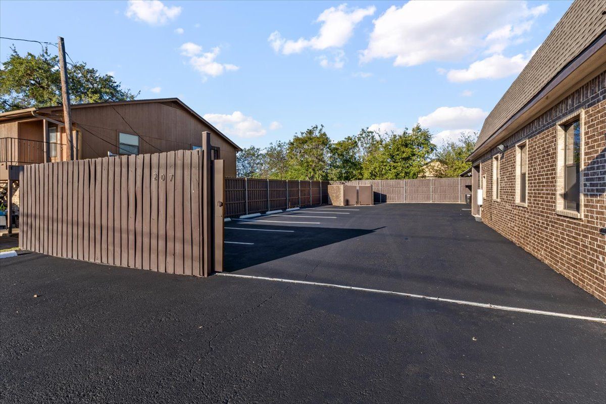 Gate opening to the fenced rear lot