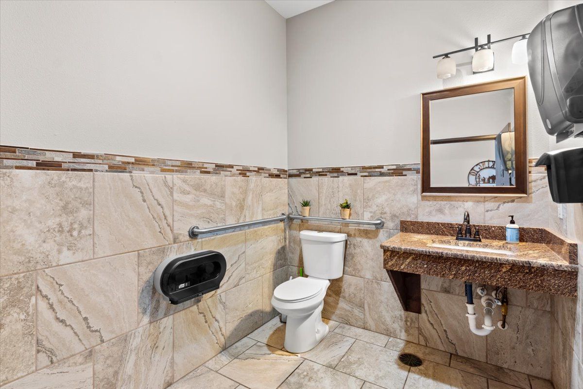 Tiled restroom with grab bars