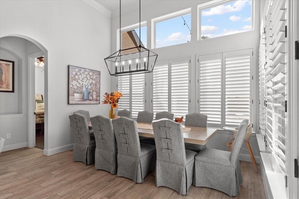 Dining area under tall windows with plantation shutters