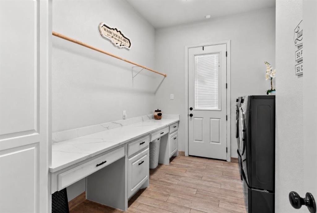 Laundry room with long counter and cabinets