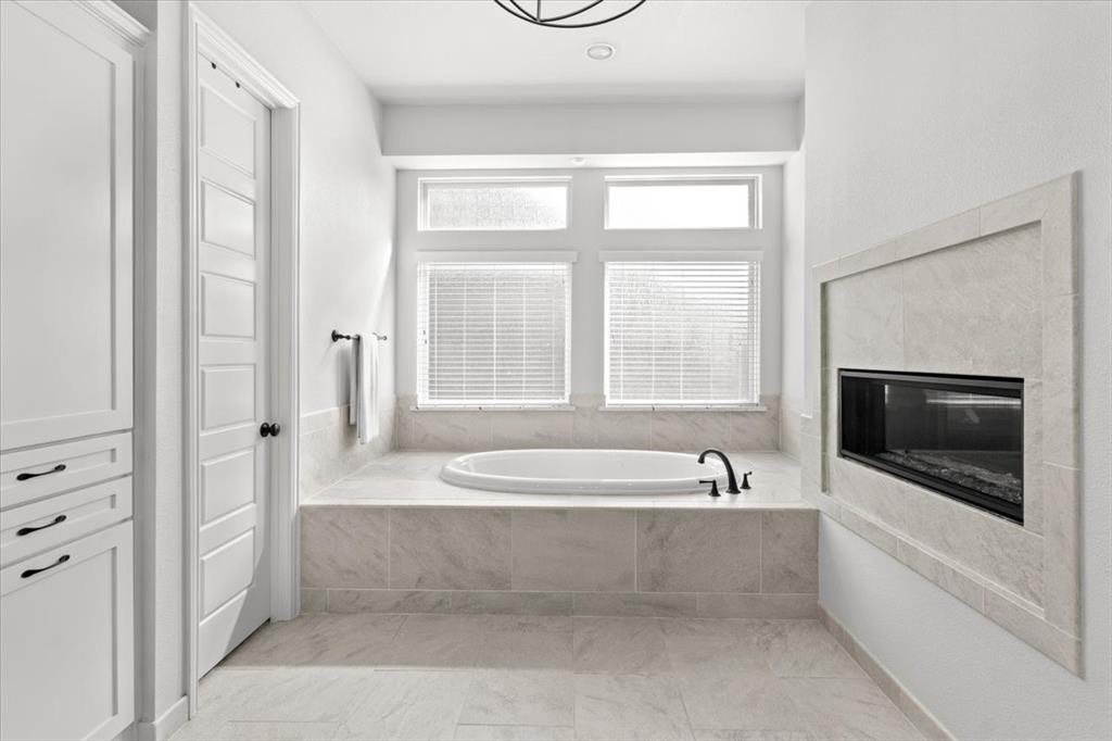 Primary bath tub with see-through fireplace