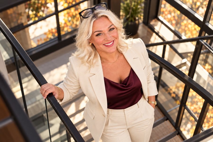 Rebecca Kennedy, Highland Village TX REALTOR, in a cream suit on a staircase